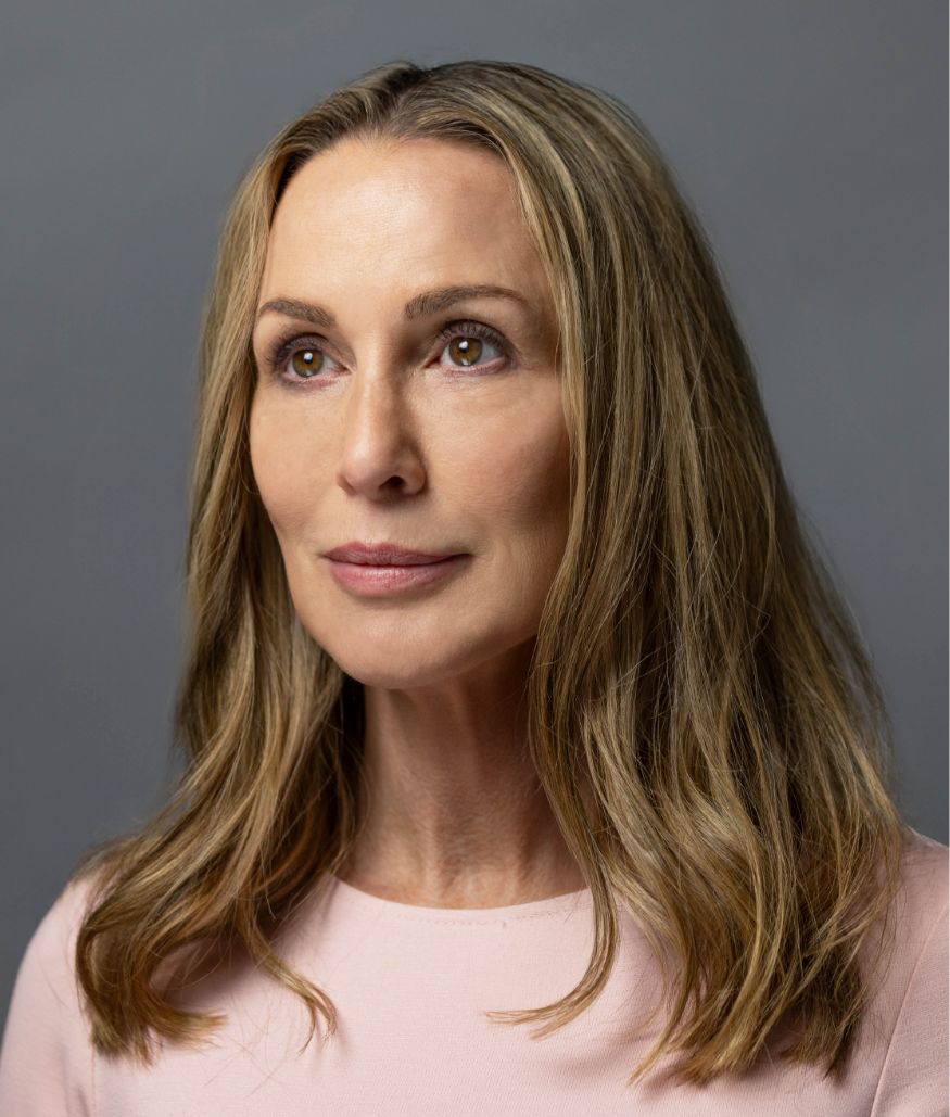 Studio portrait of woman with long blonde hair on gray background