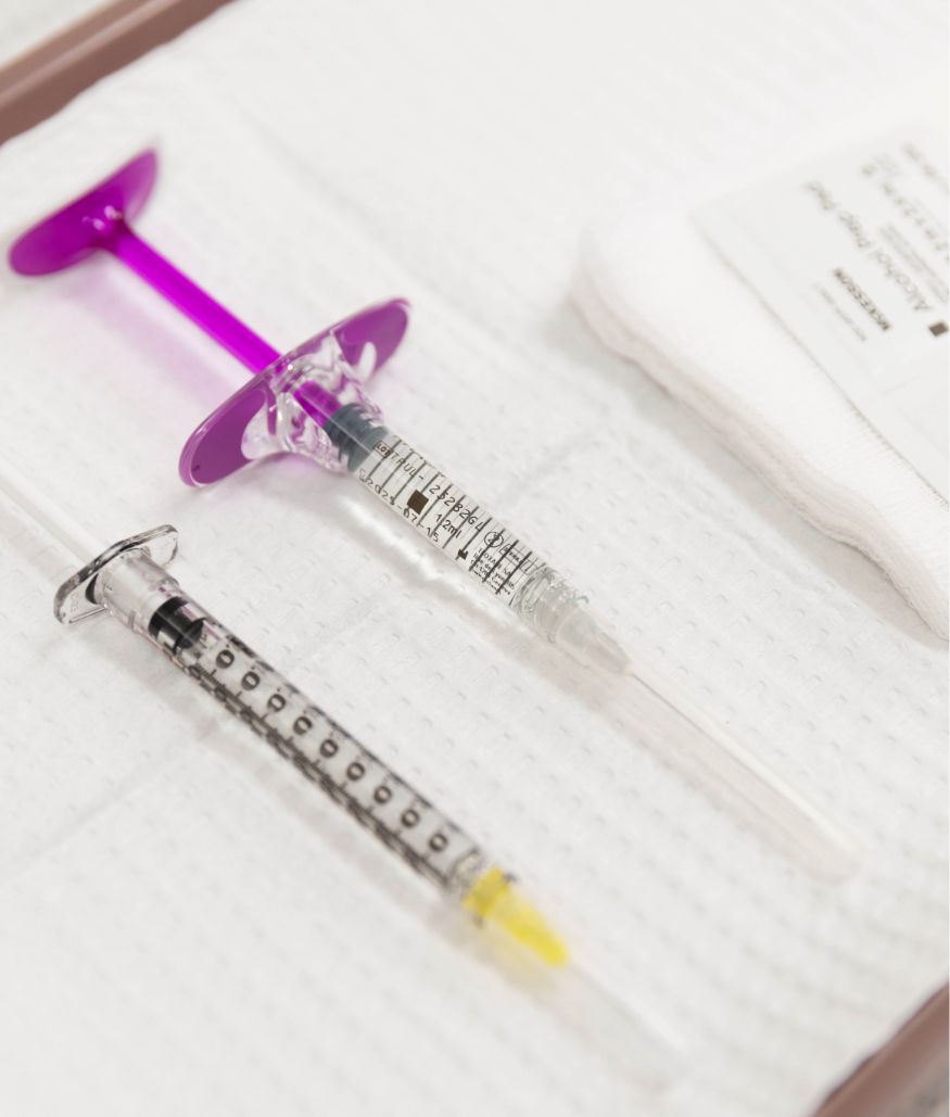 Syringes and medical supplies on a tray