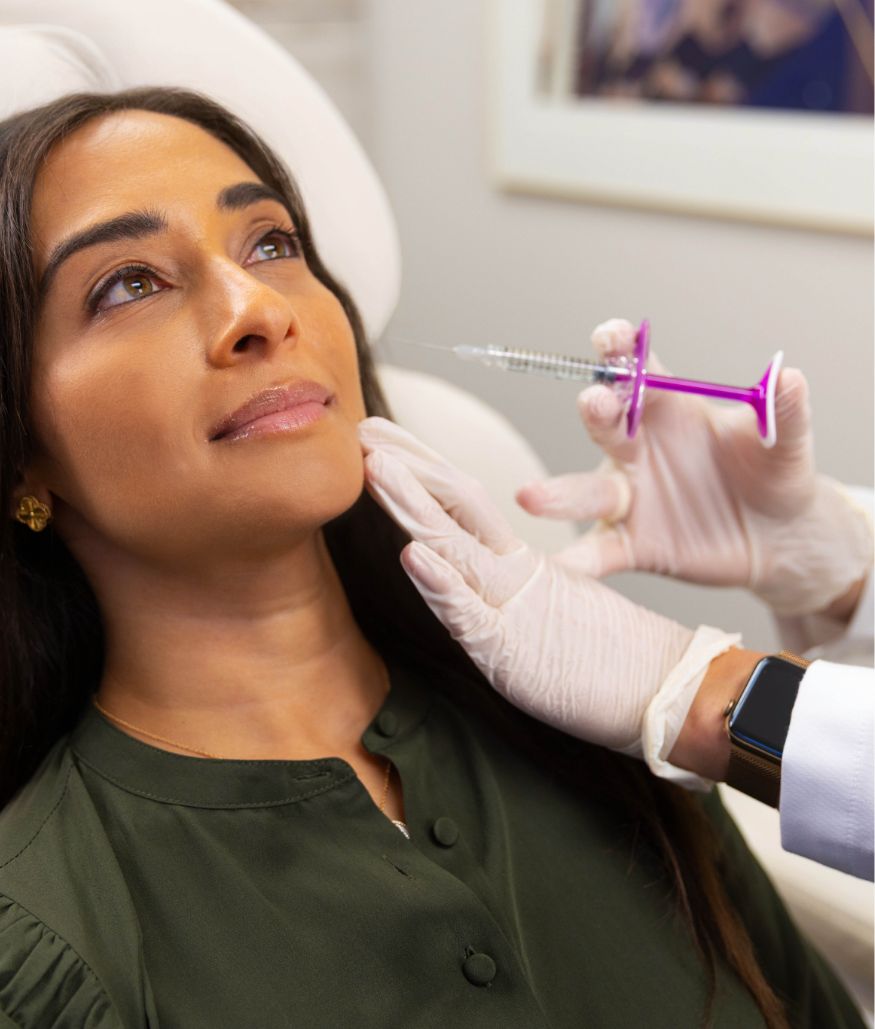 Clinician holds syringe near patient's face during consultation