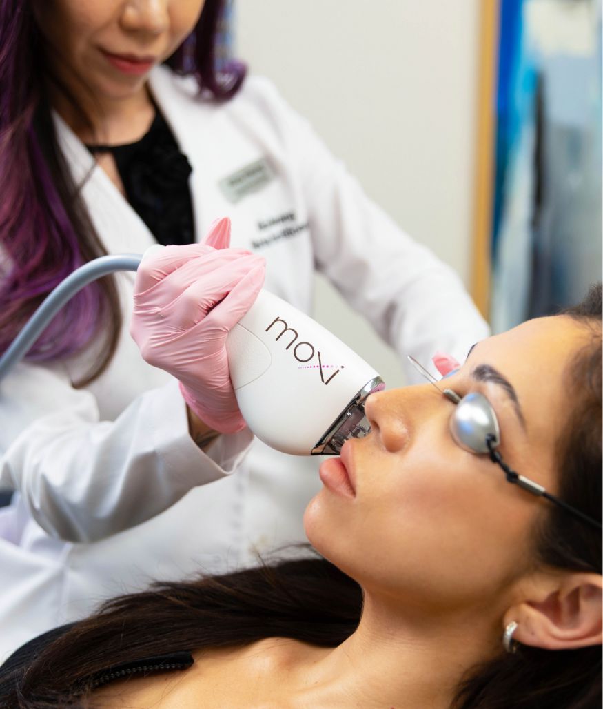 Clinician performs laser treatment on woman's face with eye shields