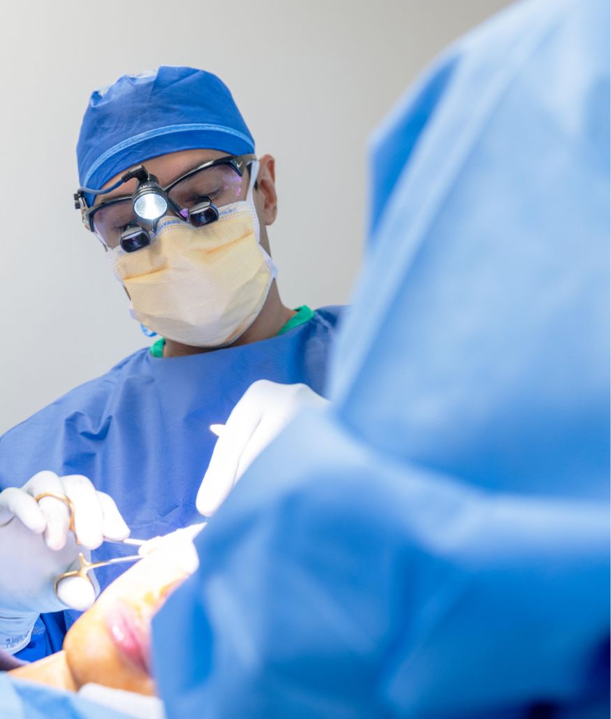 Surgeon in blue scrubs performing a procedure