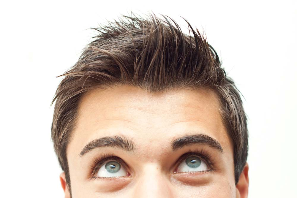 Young man with spiky brown hair staring upwards